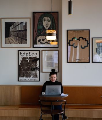 Woman on laptop at coffee shop working on ppc advertising